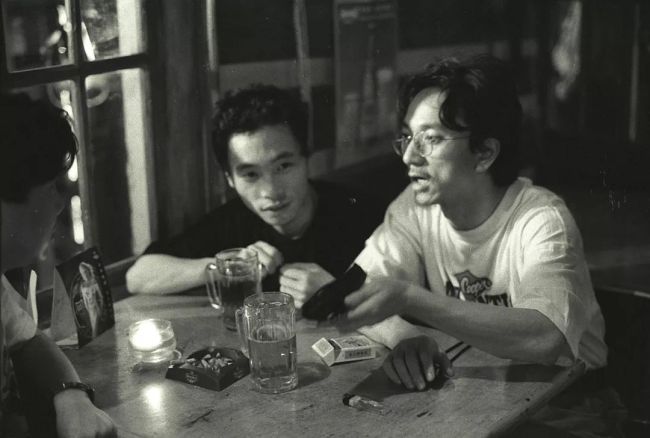 《处女作》的导演王光利（右一），1966年生于四川眉山。1989年毕业于华东师范大学教育系。1993年入住圆明园画家村。（1996年5月27日摄于实景地“栗正酒吧”）